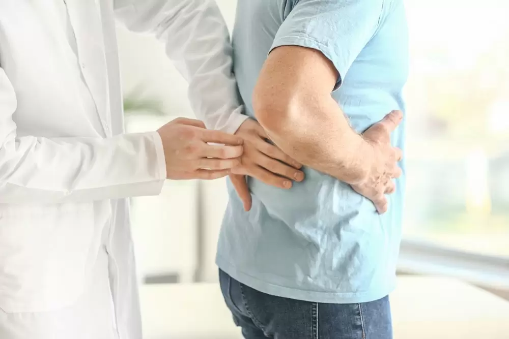 Doctor examining man with kidney pain